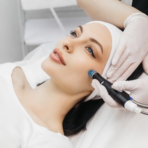 A beautiful young woman receives a hydrafacial treatment that boosts hydration and promotes skin health.